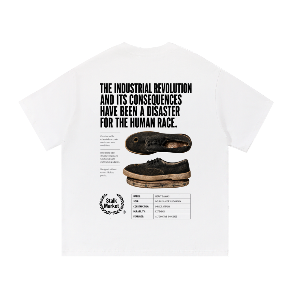 Back view of a white short-sleeve T-shirt featuring a worn industrial shoe, technical product specifications, and the headline "The Industrial Revolution and Its Consequences Have Been a Disaster for the Human Race."