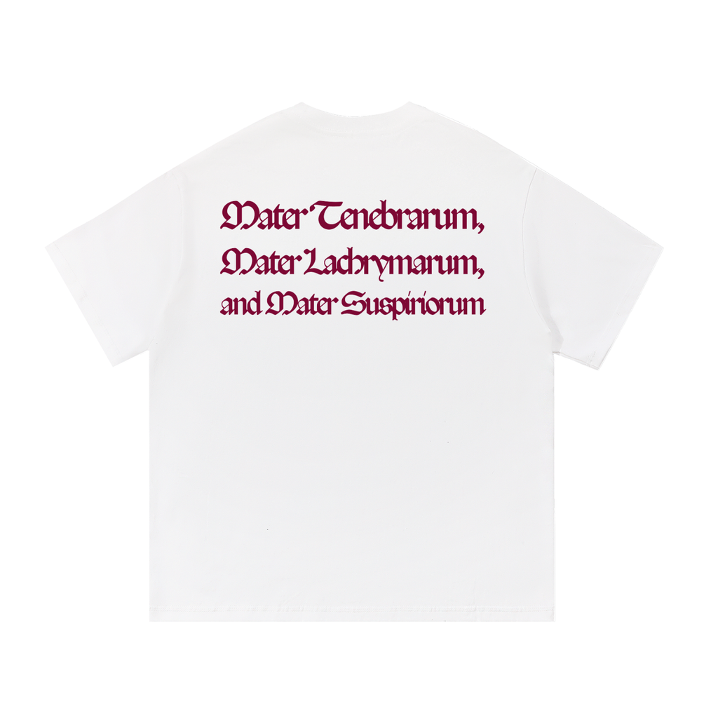 Back view of a white short-sleeve T-shirt featuring the Latin phrase "Mater Tenebrarum, Mater Lachrymarum, and Mater Suspiriorum" printed in dark red Gothic lettering.